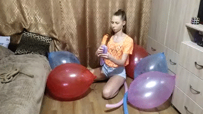 Brunette popping balloons