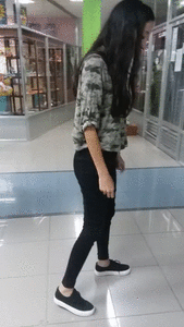 Venezuelian girl learning how to spit in a mall