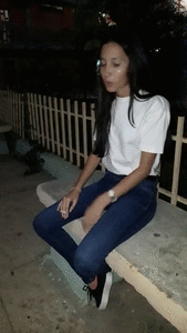 Venezuelian girl spitting and smoking on a bench