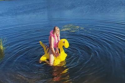 Alla rides a rare inflatable dragon on the lake.